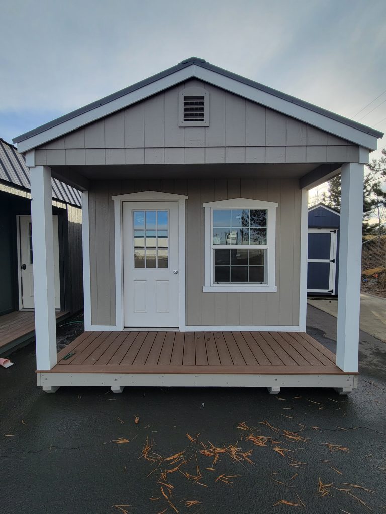 Tan shed with white trim and porch