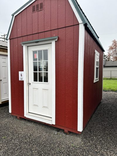 A red and white 08x12 Lofted Barn sitting in a parking lot.