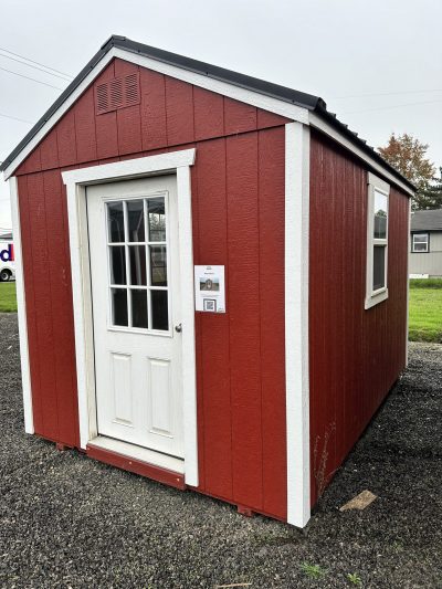 A red and white 08x12 Utility Shed sitting in a parking lot.