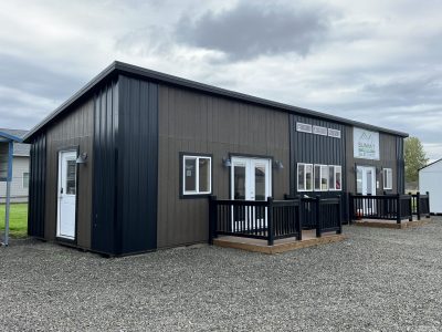 A 14x52 Studio Shed with a black door and black siding.